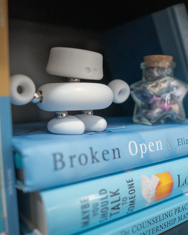 Blue books, a small white robot, and a jar of paper stars