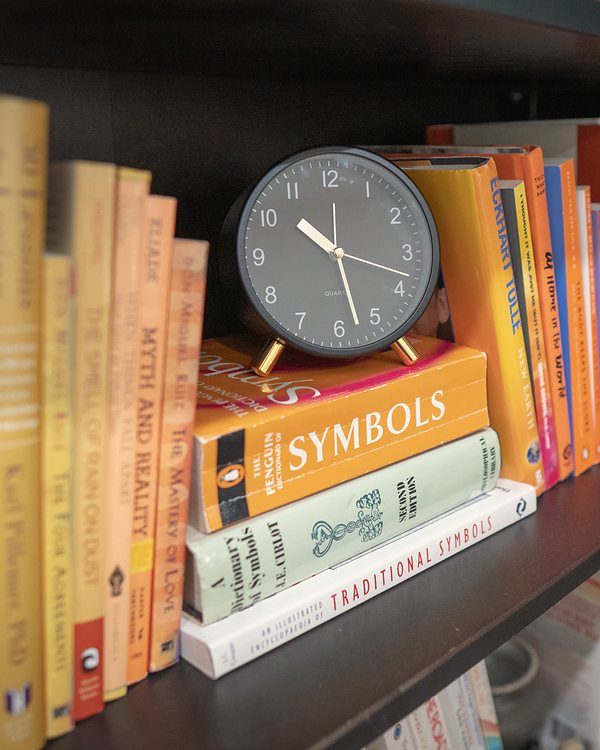 Orange and yellow books with a black clock